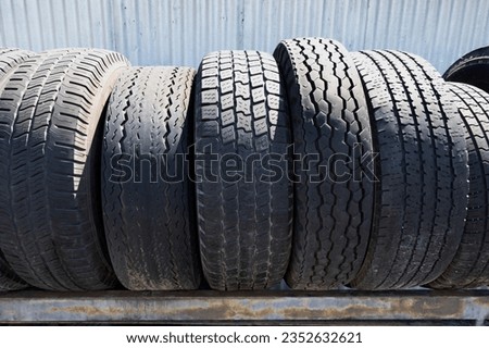 Close Up of Worn Tires on Racks Outside a Repair Shop Royalty-Free Stock Photo #2352632621