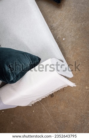 Gray couch on rustic floor with navy blue pillow