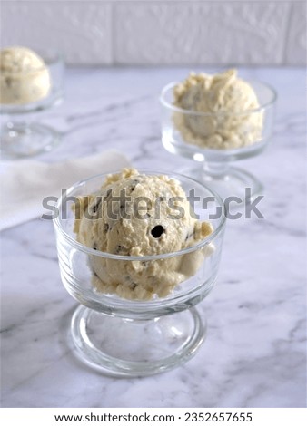 Delicious Vanilla Ice Cream scoops served in clear glass on white marble background. Oreo Vanilla Ice Cream Scoops. Harsh Light. Gelato.