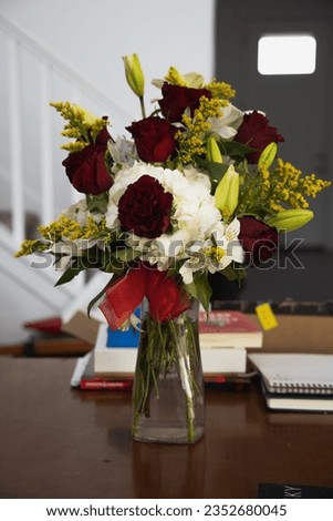 bouquet of flowers in a vase on the table with books