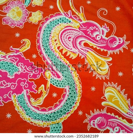Magetan 26 Agustus 2023 Dragon snake motif batik cloth in red, yellow, green, white and pink, Indonesian original manual batik with a red background Royalty-Free Stock Photo #2352682189