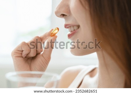 Nourishing the Body, Embracing Wellness: A Person Taking Fish Oil Supplements for Optimal Health and Vitality Royalty-Free Stock Photo #2352682651