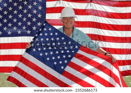 Forth of July. Photo Booth. Independence Day. American Flag Photo Booth Party. Attractive man holding Flag of the United States. Successful Entrepreneur Smiling Amid America's National Flag. USA.  