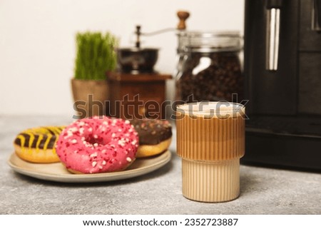 Modern coffee machine with a cup and donut on the kitchen table. Coffee house. Modern espresso coffee machine with a cup in the kitchen. Preparation of a fragrant hot drink. Place for text.Copy space. Royalty-Free Stock Photo #2352723887