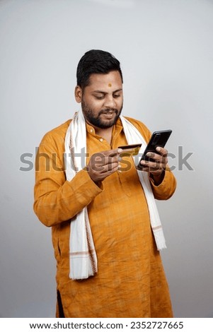 young farmer at white background  mobile phone by holding green credit card - conept of online payment, customer service and agronomy                 