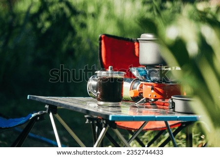 A minimalist and practical portable stove for outdoor activities and a folding table for camping needs