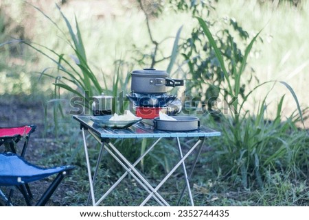 A minimalist and practical portable stove for outdoor activities and a folding table for camping needs