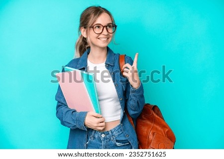 Young student woman isolated on blue background pointing up a great idea