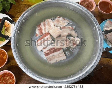 Pictured above, pork belly, bacon and soup on the stove for the Moo Kratha menu, Popular food of Thai people.
