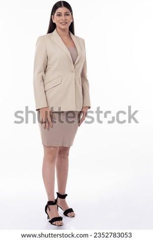 Portrait of Indian businesswoman dressed in formalwear with arms crossed standing confidently against white background.
