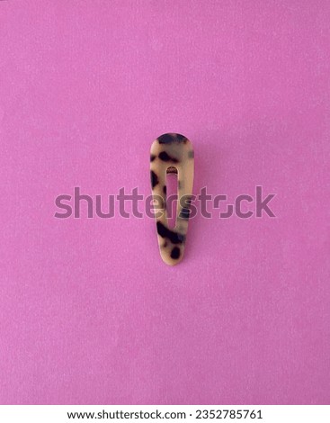 leopard print hair clip on a pink background