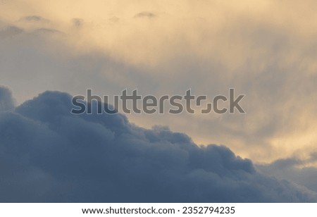 Sunset sky with majestic black clouds floating around.
