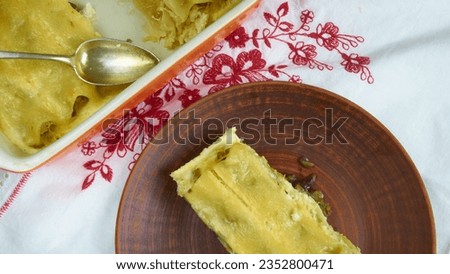 Italian cannelloni with cream in brown plate on the white wood table and tablecloth. Close up food photography for advertising, blog, magazine, recipe