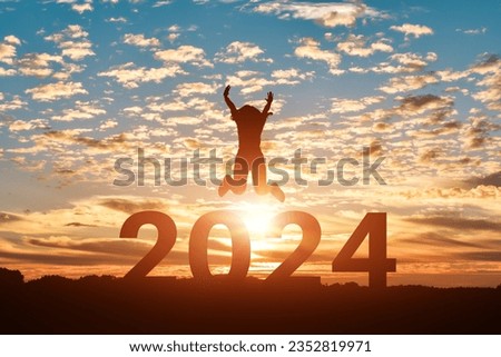 Silhouette of woman jumping to Happy new year 2024 in sunset or sunrise background.