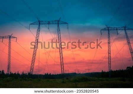 Electricity pylons and cables against the stormy sunset sky on TransCanada Highway on Route 1 in St John, New Brunswick, Canada, abstract artificial shapes and geometry in nature Royalty-Free Stock Photo #2352820545
