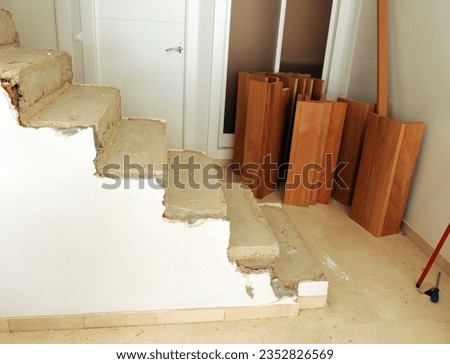 Concrete steps of the internal staircase of a two-story house prepared to be lined with solid beech wood steps. Carpentry and interior design work. Royalty-Free Stock Photo #2352826569