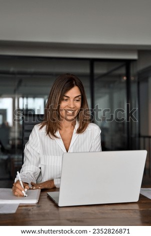 Middle-age Hispanic woman using laptop computer for business studying, watch online virtual webinar training meeting,video call. Focused mature 40s years Latin businesswoman work in office, vertical Royalty-Free Stock Photo #2352826871