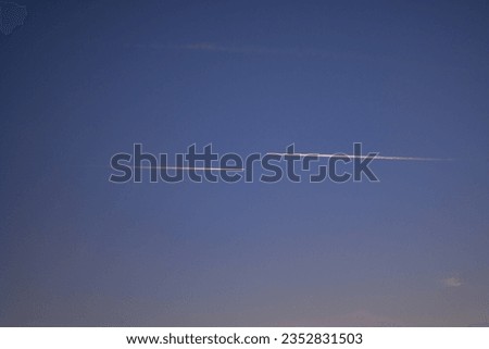 Two passenger planes passing parallel in the blue sky. Traces made by aircraft 