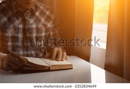 young man was praying to God in front of Bible with faith and power of faith in God. Bible study concept to understand and pray to God with faith in teachings of the Bible studied. Copy Space