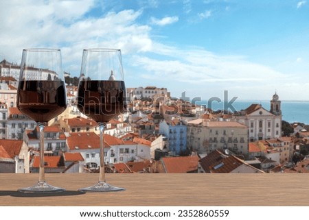 Two glasses of red wine on view of the Lisbon old town in Alfama district in Lisbon, Portugal Royalty-Free Stock Photo #2352860559