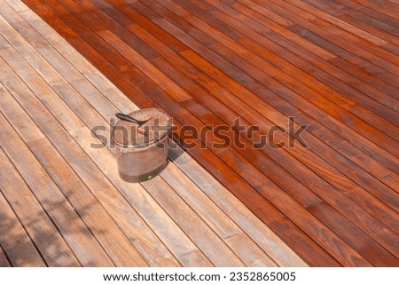 Wood deck renovation treatment and maintenance concept, paint brush on the bucket with oil, staining wooden decking Royalty-Free Stock Photo #2352865005