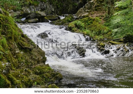 small waterfall in the forest with some green at Rhaeadr Nantcol Waterfalls, UK