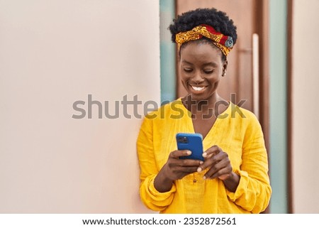 Young african american woman smiling confident using smartphone at street Royalty-Free Stock Photo #2352872561