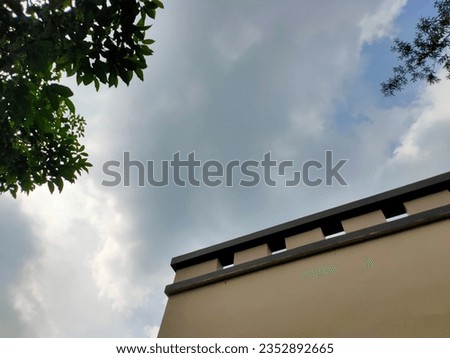 Cloudy blue sky with brpen modern buildings and leaves