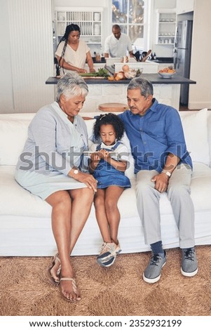 Home, family and grandparents with girl, tablet and weekend break with fun, social media and streaming movies. Granny, old man or kid on a sofa, technology or cartoons with application, film or relax