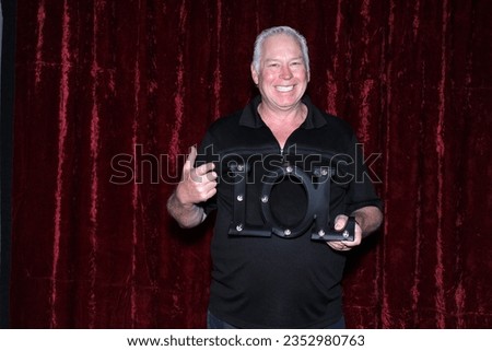Photo Booth. A man Smiles and Laughs as he poses for his picture to be taken while in a Photo Booth at a Party. Photo Booths are loved at Weddings and all Parties. Guest pose for photos. Photo Booth. 