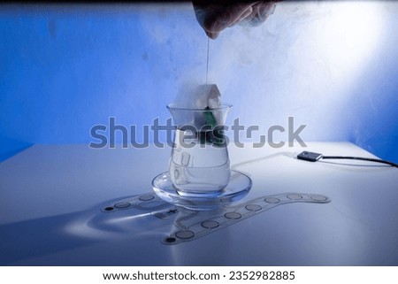 Tea glass with water with tea bag with computer processor with steam