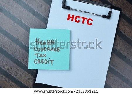 Concept of HCTC - Health Coverage Tax Credit write on sticky notes isolated on Wooden Table.