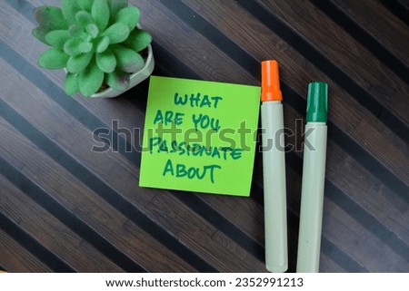 Concept of What Are You Passionate About write on sticky notes isolated on Wooden Table.