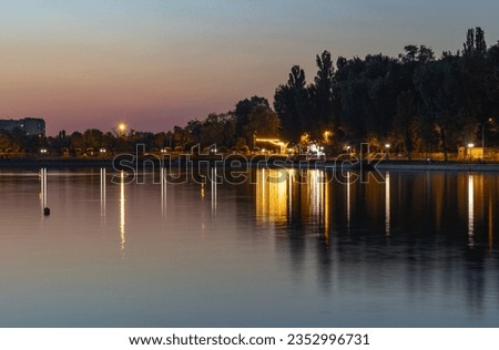 Beautiful sunset and lights reflection on a lake in a public park in Chisinau, Moldova