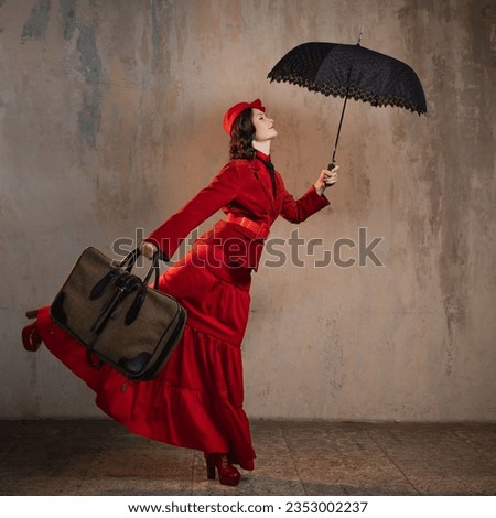 A stylish lady in a red old-fashioned suit with a hat and a lace umbrella Royalty-Free Stock Photo #2353002237