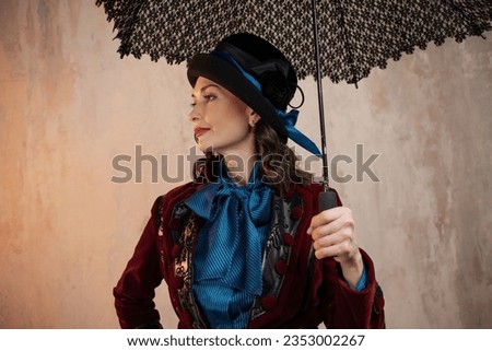 Mary Poppins. A stylish lady in a burgundy old - fashioned suit with a hat and a lace umbrella . Brunette in a retro style suit Royalty-Free Stock Photo #2353002267