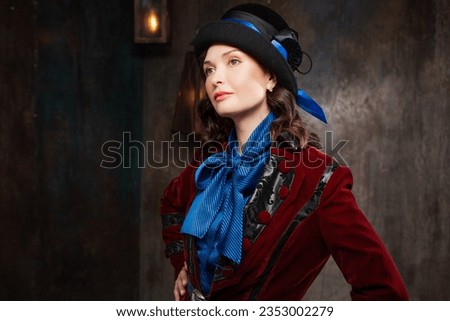 A stylish lady in a burgundy old - fashioned suit with a hat . Brunette in a retro style suit Royalty-Free Stock Photo #2353002279
