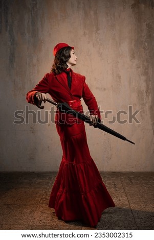 Mary Poppins. A stylish lady in a red old-fashioned suit with a hat and a lace umbrella Royalty-Free Stock Photo #2353002315