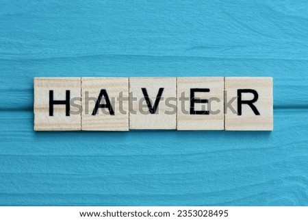 word haver made from wooden gray letters lies on a blue background