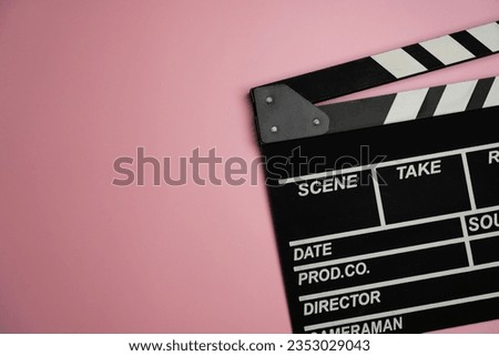 movie clapper on pink table background ; film, cinema and video photography concept