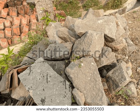 Photo of a stack of large and dry rocks beside the road taken from a high angle.