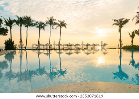 umbrella with bed pool around swimming pool with ocean sea background at sunset or sunrise time - holiday and vacation concept Royalty-Free Stock Photo #2353071819