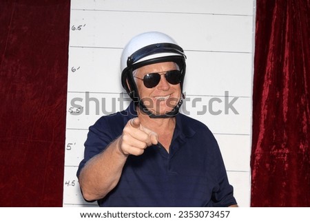 Photo Booth. Motorcycle Police Officer in front of a Police Booking Sign. When under arrest you get your Mug Shot Picture taken by the Police. Police Hand Cuffs. Cops are important people. Friendly. 