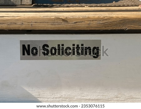 A No Soliciting sign placed elegantly on home entrance wooden stairs. Clear communication for a private environment. Ideal for various projects.