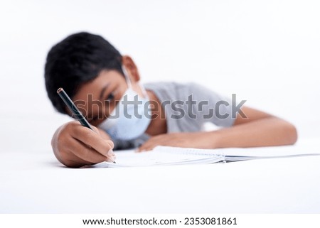 Boring little boy doing homework at home 