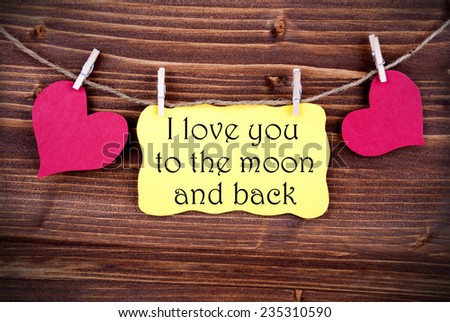 Yellow Tag Or Label With Two Hearts On A Line With I Love You To The Moon And Back On Wooden Background, Two Symbols, Vintage, Retro And Old Fashion Style With Frame