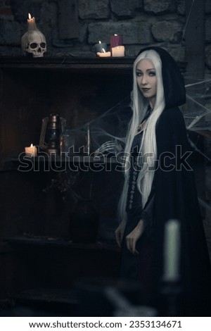 blonde witch with long hair in a black hoodie is preparing a witchcraft potion with a skull, candles, potions and cooking ingredients