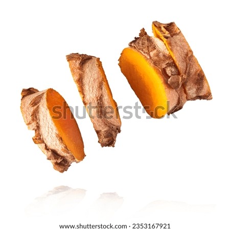 Fresh turmeric root falling in the air isolated on white background. Food levitation conception. High resolution image.
