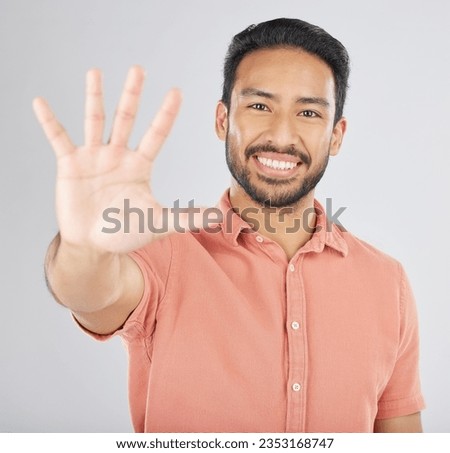 Smile, hand and portrait of man with stop gesture happy for communication isolated in a studio white background. Asian, sign language and confident young person with signal, symbol and hello sign