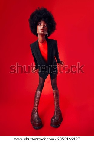 Black woman, afro and hair with fashion and style, edgy with designer clothes and gen z isolated on red background. Mockup space, stylish clothing and trendy African model with hairstyle in a studio